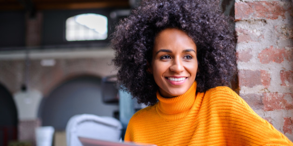 mvb vrouw kijkt lachend naar laptop