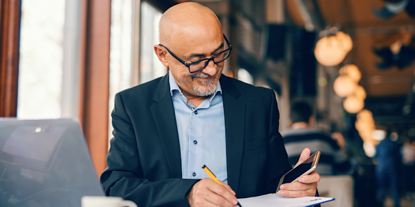 man met bril schrijft