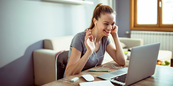 vrouw met oortjes in achter laptop